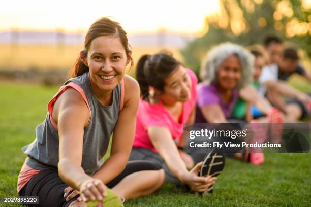 woman stretching in group fitness class - yoga outdoors stock pictures, royalty-free photos & images