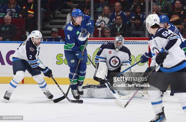 Brock Boeser of the Vancouver Canucks screens Connor Hellebuyck of the Winnipeg Jets during their NHL game at Rogers Arena on February 17, 2024 in...