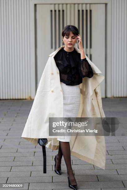 Guest wears creme white coat, white skirt, black laced top, tights, heels outside Alberta Ferretti during the Milan Fashion Week - Womenswear...