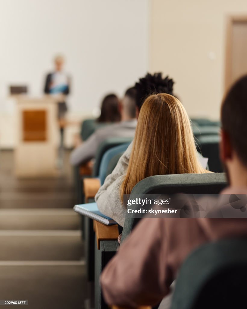 Rear view of students on a class at lecture hall.