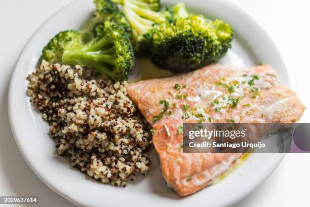 plate of salmon with quinoa and broccoli - quinoa stock pictures, royalty-free photos & images