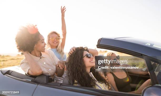 girlfriends having fun on road trip with car - wonderlust stock-fotos und bilder