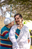 caucasian gay couple embracing looking at