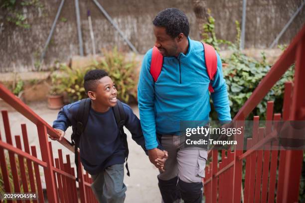 arrival: father and 10-year-old son return home together - 40 year old black man stock-fotos und bilder