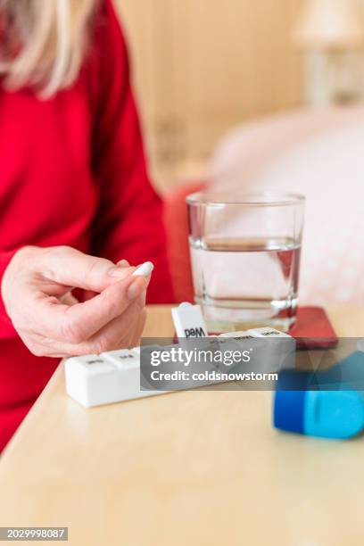 seniorin, die medikamente aus der täglichen pillendose einnimmt - tablettenbehälter stock-fotos und bilder