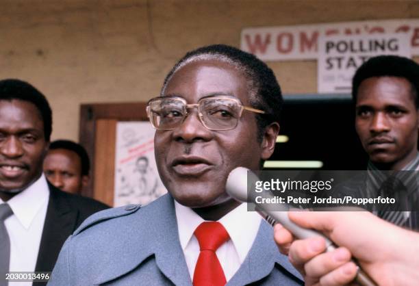 Zimbabwean politician Robert Mugabe is interviewed outside a polling station after registering his vote on the first day of voting in the 1980...