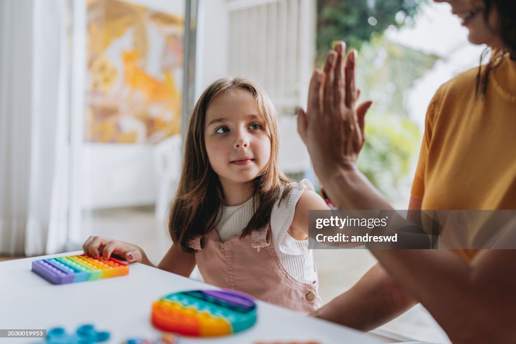 Mother playing with autistic daughter