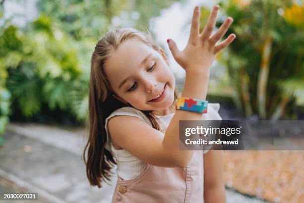 pulsera del símbolo del autismo de la niña autista - neurodiversidad fotografías e imágenes de stock