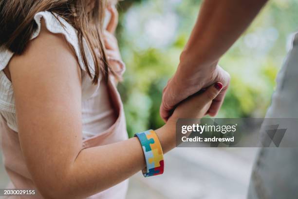bambino autistico che si tiene per mano con sua madre - autismo foto e immagini stock