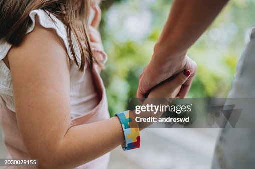 Autistic child holding hands with his mother Autistic child holding hands with his mother