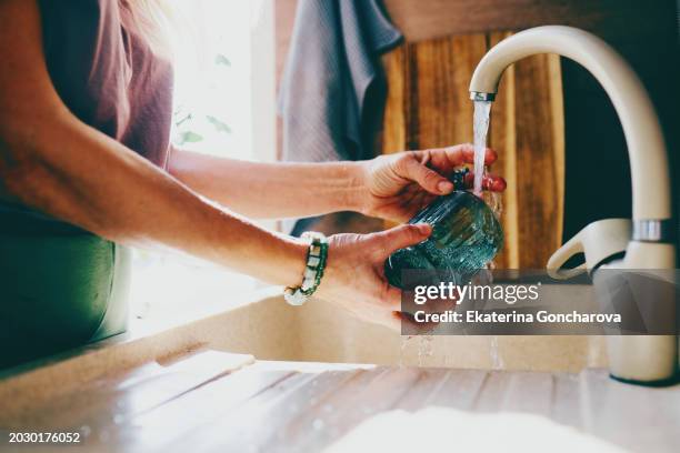 hand washing textured green glass under kitchen tap - water conservation stock pictures, royalty-free photos & images