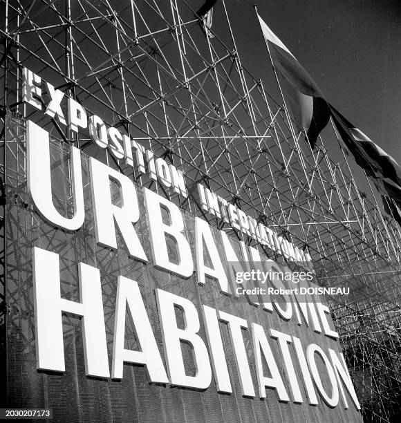 Panneau "Exposition internationale de l'urbanisme et Habitation" sur un échafaudage devant le Grand Palais à Paris en 1947.