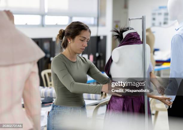 modedesign-studentin näht ein kleid an einer schaufensterpuppe - schneiderin stock-fotos und bilder