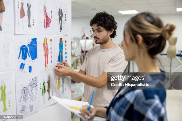 fashion design student explaining his designs to his teacher - modestylist stockfoto's en -beelden