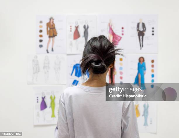 fashion design student looking at sketch illustrations at the atelier - student fashion stock pictures, royalty-free photos & images
