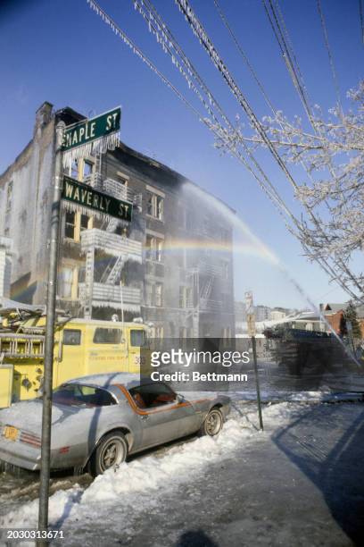 Plumes of spray from a firefighter's hose form a rainbow and icicles during freezing weather conditions in Yonkers, New York, February 9th 1979....