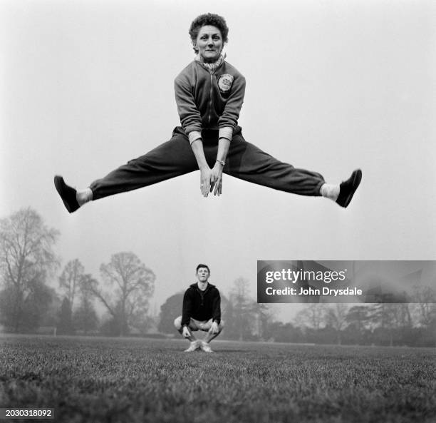 British athlete Dorothy Tyler is watched by ballet dancer David Drew as she practices a ballet-style jump during training at Bisham Abbey,...