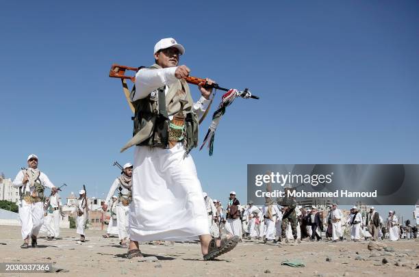 Yemen's Houthi followers carry their rifles as they participate in a rally and parade staged against Israeli and its allies USA and UK for their...