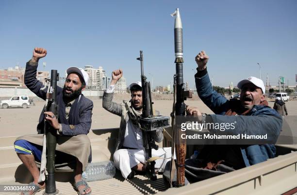 Yemen's Houthi followers holding their weapons ride vehicles as they participate in a rally and parade staged against Israeli and its allies USA and...