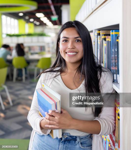 estudante universitário em busca de livros na biblioteca - vertical - fotografias e filmes do acervo