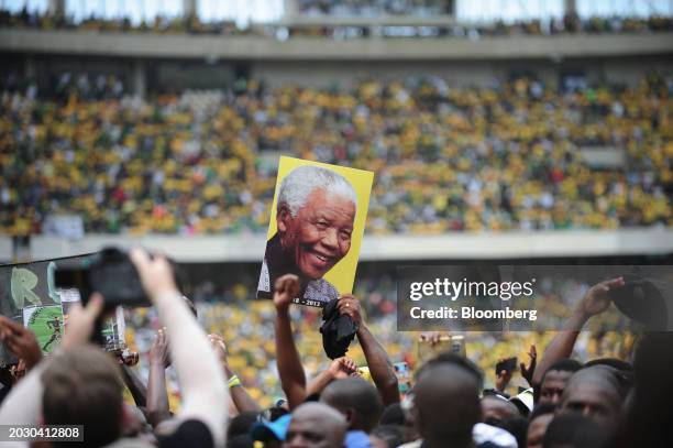 Supporters wave a placard of former South African president Nelson Mandela at the the African National Congress party manifesto launch in Durban,...