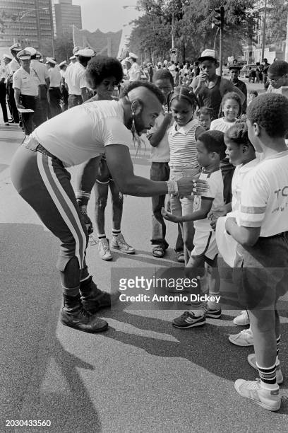 Mr T speaks to a group of children at the start of the annual Bud Billiken Parade held on the South-Side of Chicago, Illinois, 11th August 1984.