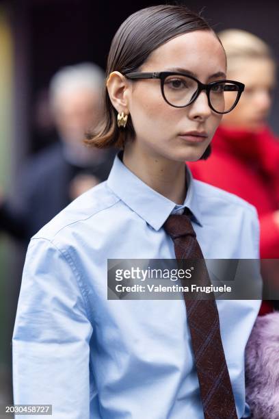 Guest is seen wearing gold hoop earrings, a brown and blue printed tie and a light blue shirt outside Max Mara show during the Milan Fashion Week -...
