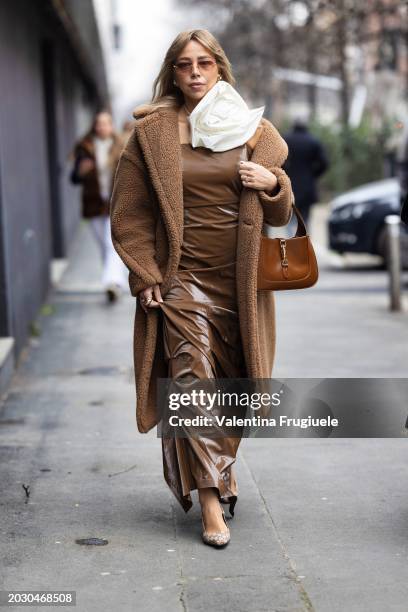 Guest is seen wearing pearl earrings, Gucci pumps, a white 3d fabrics flower chocker, brown sunglasses, a beige teddy coat, a vinyl beige long dress...