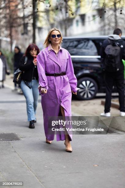 Veronica Ferraro is seen wearing blue sunglasses, beige leather pumps, a brown leather belt, a pink shirt and a lilac cargo long denim trench outside...