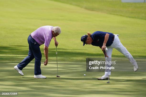 Colin Montgomerie of Scotland and Miguel Angel Jimenez of Spain check on a small detail on the 7th green during the first round of the Trophy Hassan...