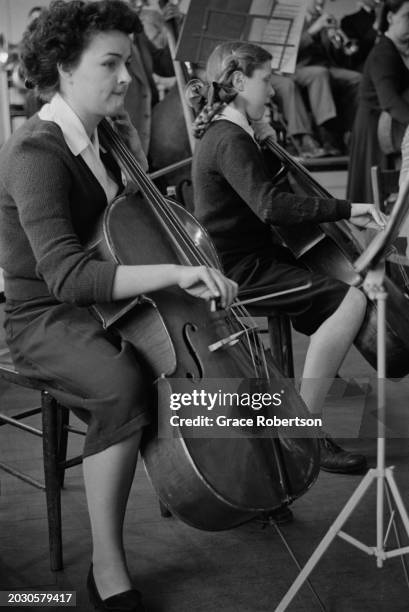 Pat Pamment, of the London County Council's Symphony Orchestra for Schoolchildren, playing cello during rehearsals for a private concert at the Royal...