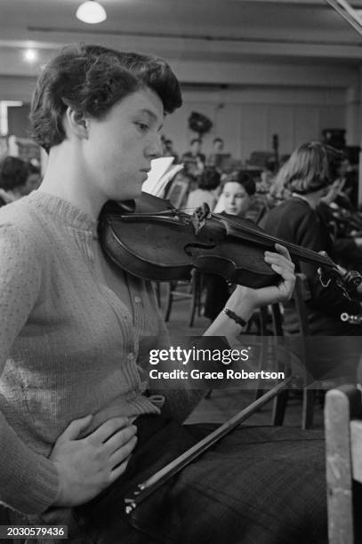 Student of London County Council's Symphony Orchestra for Schoolchildren, with a violin during rehearsals for a private concert at the Royal College...