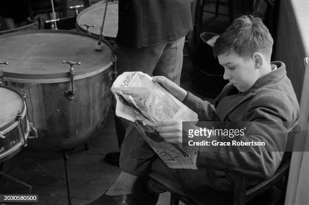 Student of the London County Council's Symphony Orchestra for Schoolchildren reads the newspaper in between rehearsals, during a five day holiday...