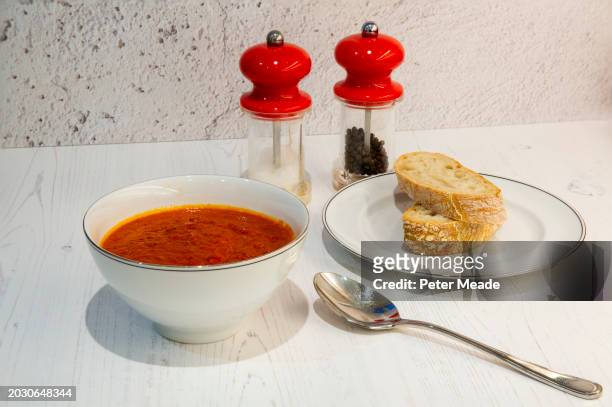 a freshly made bowl of tomato and red pepper soup with some fresh bread - soup bowl stock pictures, royalty-free photos & images