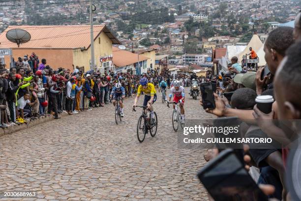 Residents gather to look at Israel Premier Tech's British rider Joseph Blackmore , competing during the final stage of the 16h Tour du Rwanda on 25...