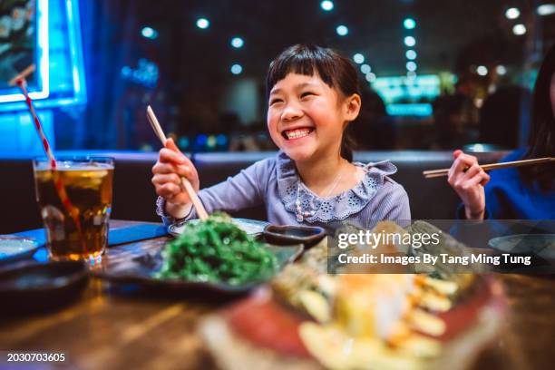 lovely cheerful girl enjoying meal with family in a local japanese restaurant during vacation - noodle soup stock pictures, royalty-free photos & images