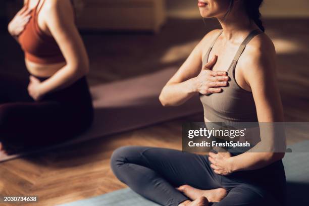 donne che praticano yoga in un ambiente di studio calmo per il benessere - zen foto e immagini stock