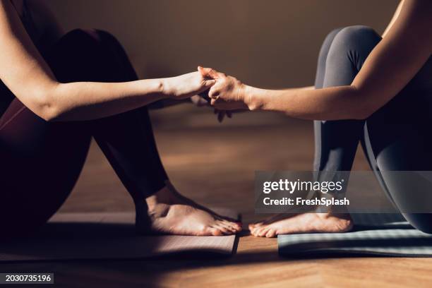 close-up of two people practicing partner yoga in a serene setting - trust exercise stock pictures, royalty-free photos & images