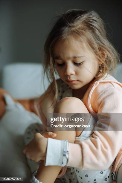 pies de niño con lesiones y rasguños. niño con rodillas lesionadas y heridas sobre un fondo gris. - cardenal lesión física fotografías e imágenes de stock