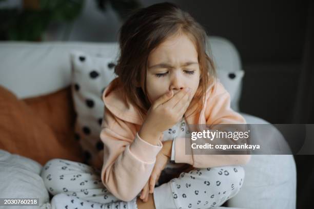 petite fille malade toussant dans le salon - virus grippal photos et images de collection