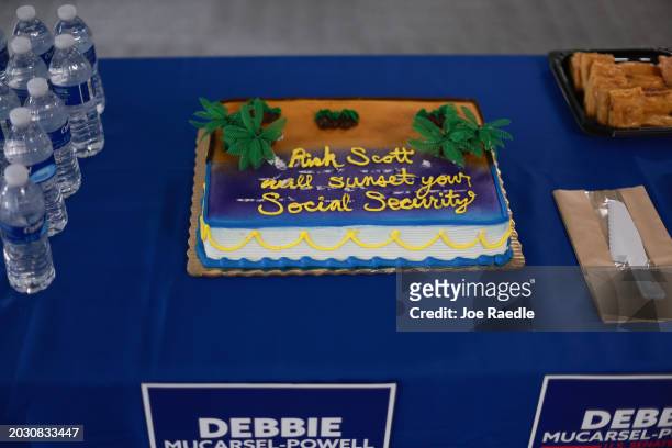 Cake reading "Rick Scott will sunset your Social Security" is served during a campaign event for Florida Democratic Senate candidate Debbie...