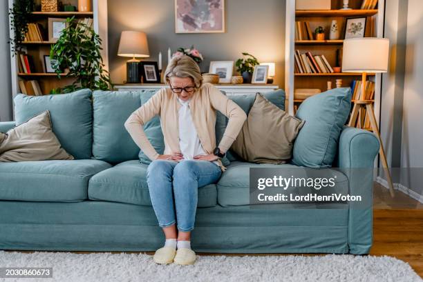 mujer que sufre de calambres estomacales - enfermedad crónica fotografías e imágenes de stock