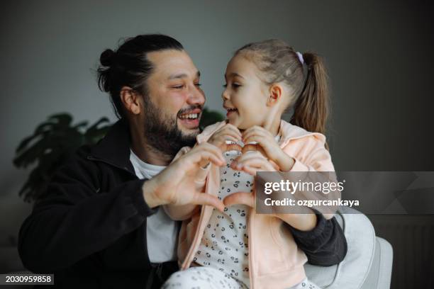 father and cute little child daughter showing love sign. - truehearts stock pictures, royalty-free photos & images