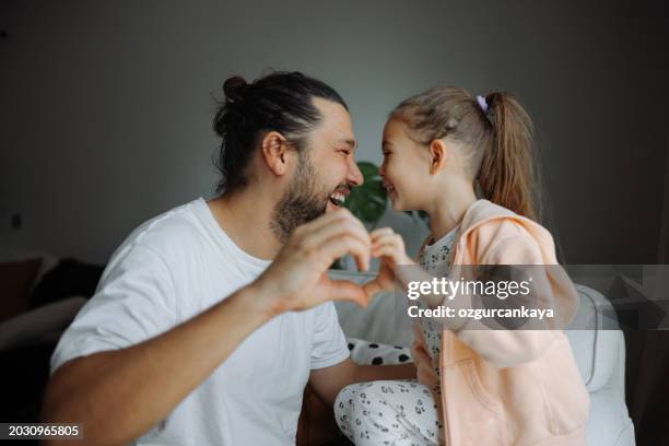 father and cute little child daughter showing love sign. - truehearts stock pictures, royalty-free photos & images