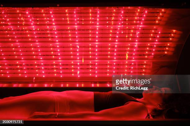 woman on an led bed receiving red light therapy - infrared lamp stock pictures, royalty-free photos & images