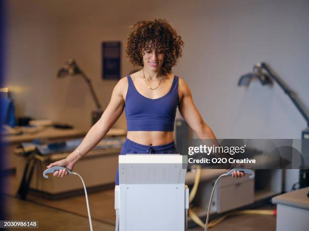woman using a body composition analysis machine - equipamento de exame médico por imagem de diagnóstico imagens e fotografias de stock
