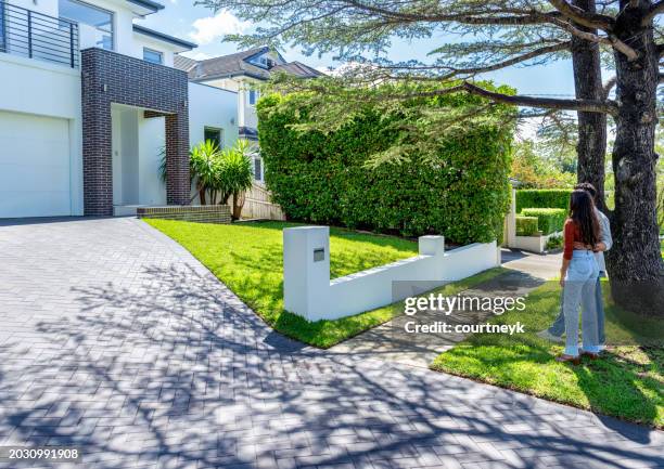 happy couple standing in front of their new home. - home renovations australia stock-fotos und bilder