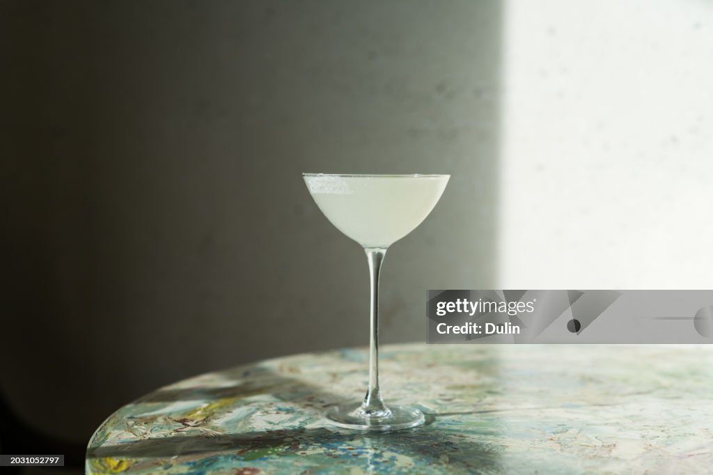 Close-up of a martini cocktail on a table in sunlight