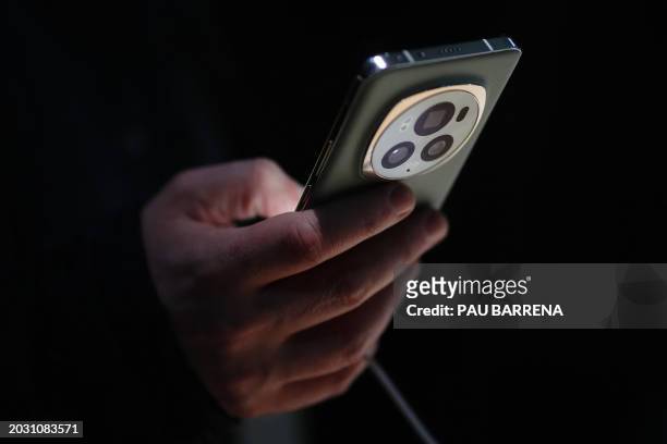 Man uses the new Honor Magic 6 Pro smartphone during a presentation on the eve of the Mobile World Congress , the telecom industry's biggest annual...