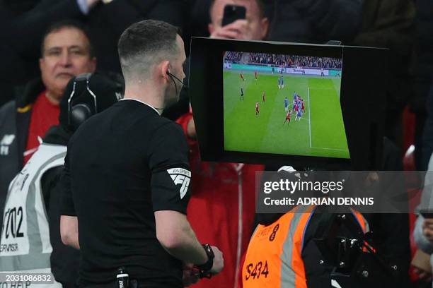 English referee Chris Kavanagh checks the pitch-side monitor before overturning a 'goal' by Liverpool's Dutch defender Virgil van Dijk after a VAR...